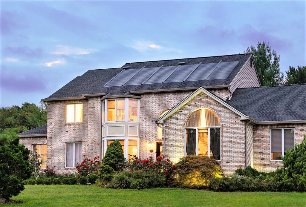A large brick house in Galt with solar panels on the roof, showcasing the advanced roofing solutions by DavisRoofingGroup.